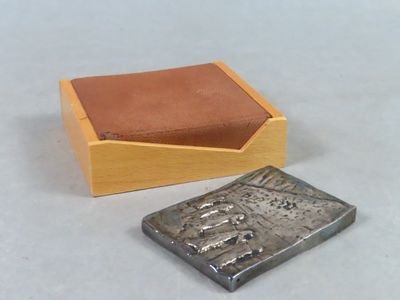 une petite boîte en bois contenant un petit objet en métal