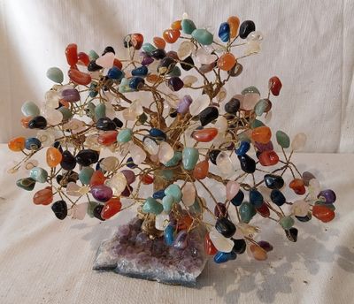 une sculpture représentant un arbre, réalisée à partir de pierres et de perles