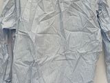 blue and white striped shirt with yellow african print on the chest