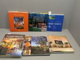 Plusieurs livres sont posés sur une table devant un mur blanc.