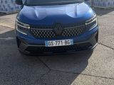 une voiture bleue garée sur un parking, à côté d'une pile de cartons