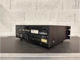 a black amplifier sitting on top of a table next to a brick wall