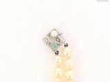 a white pearl bracelet with a diamond clasp on it