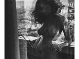 une photo en noir et blanc d'une femme debout sur un balcon