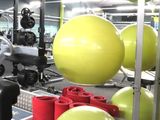a gym room with a variety of exercise balls on the floor