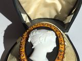 a small box with a broochee in the shape of a woman ' s head