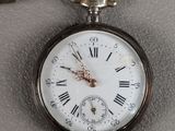 a silver pocket watch with roman numerals on it