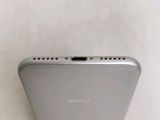 a close up of the back of a silver phone on a white surface