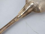 a silver spoon with a long handle on a table