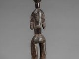 a wooden statue of a man with a hat on his head