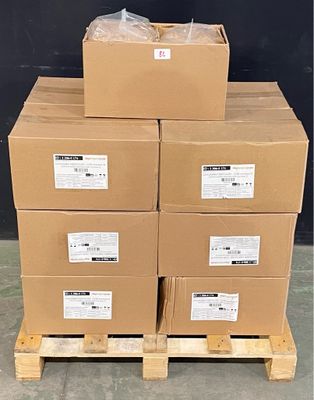 boxes stacked on a pallet in front of a black wall
