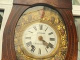a wooden clock with roman numerals on the face