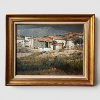 une image représentant un tableau d'un village, dans un cadre doré