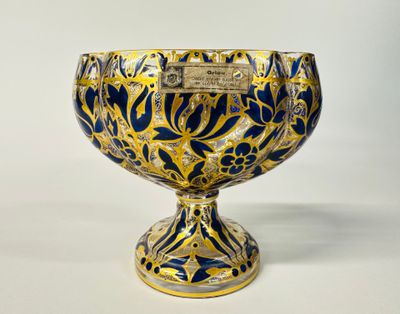 a blue and gold vase with a plaque on it