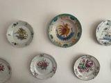 many plates on the wall that have different designs on them