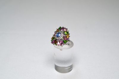 ring with multicolored stones in a clear glass vase