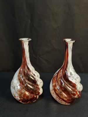 deux vases marron et blancs posés sur une table noire