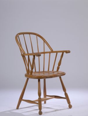 a wooden chair that is sitting on a white surface
