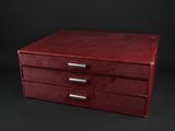 a red leather box with three drawers on a black background