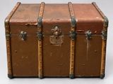 a brown trunk with metal handles on a white surface