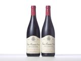 two bottles of red wine sitting on top of a table