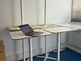 a laptop on a desk in a room with blue carpet