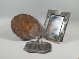 a silver plate and a silver picture frame on a stand