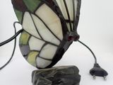 a lamp that is sitting on a rock with a butterfly on it
