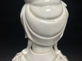 a white statue of a woman with a hat on her head