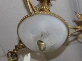 a chandelier hanging from the ceiling with a bird on it
