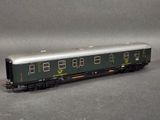 a green train car that is sitting on a gray surface