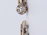two pairs of gold and diamond earrings on a white surface