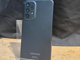 a close up of a black samsung galaxy s20 on a wooden table