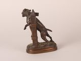 bronze statue of a dog on a post with a bird in its mouth