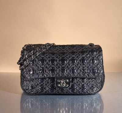 black chanel bag on table with reflection on surface