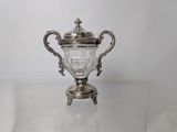 a silver cup sitting on a glass table