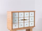une armoire en bois dotée de nombreux tiroirs, dans une pièce blanche