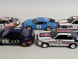 several toy cars are lined up in a row on a white surface