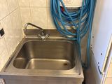 un lavabo muni d'un tuyau d'arrosage dans une salle de bains