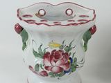 a white vase with red and green flowers on it