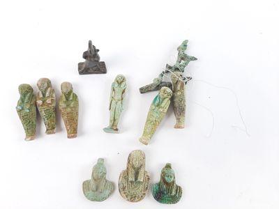 several ancient figurines are displayed on a white surface