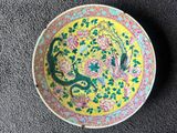 a yellow plate with a bird and flowers design on it