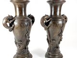 two vases that are sitting side by side on a white surface