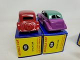 three toy cars sitting on top of boxes on a white surface