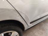 a white car that has been dented and is parked in a garage
