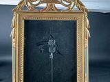 a gold frame with a picture of a bird on it