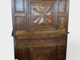 une vieille armoire en bois ornée d'un motif en forme d'étoile sur le dessus