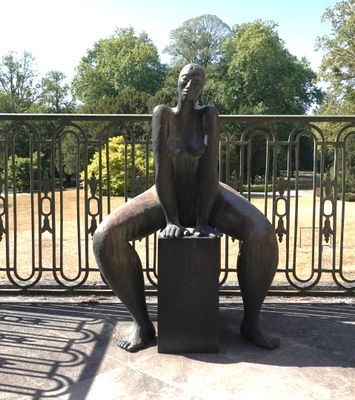 une statue représentant un homme assis sur un banc