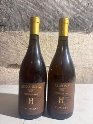 two bottles of wine sitting on a table next to each other