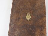 un livre marron orné d'un emblème doré